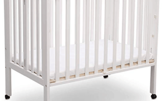 Delta Children Portable Mini Crib in white open on wheels