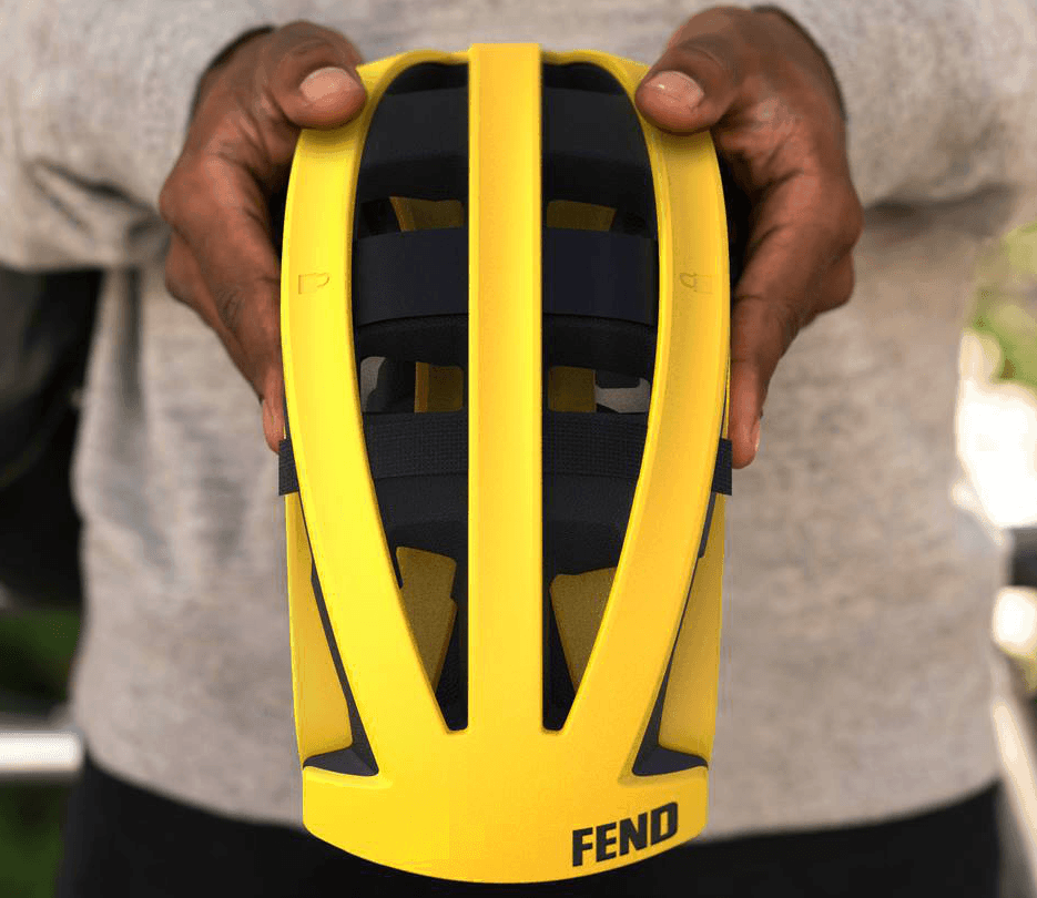 Fend helmet in yellow front view being held folded