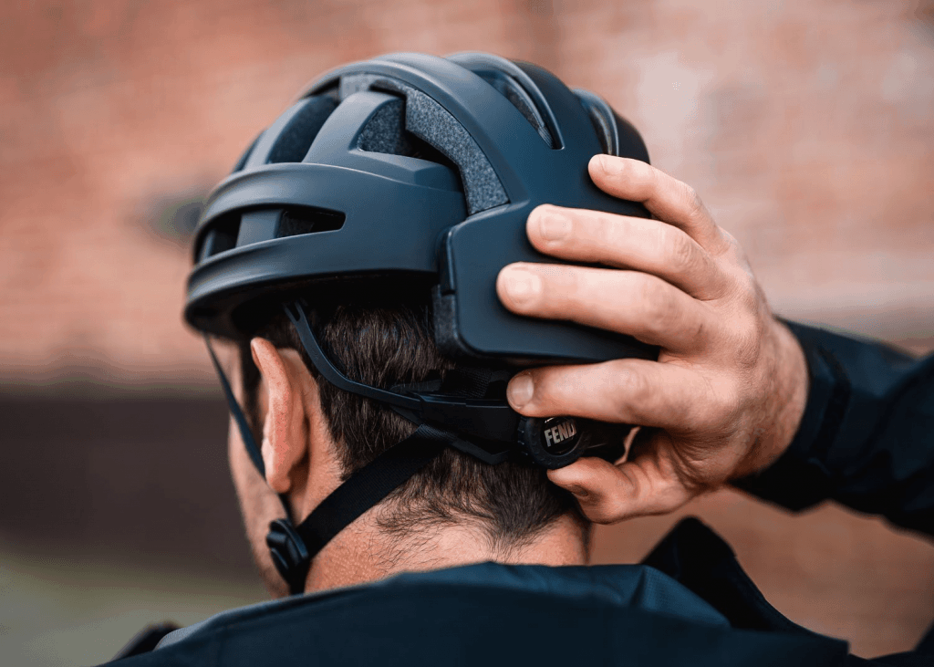 Fend helmet rear view showing man adjusting tightness adjustor