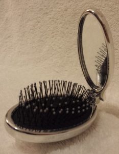 Wet Brush in silver half folded showing mirror on handle